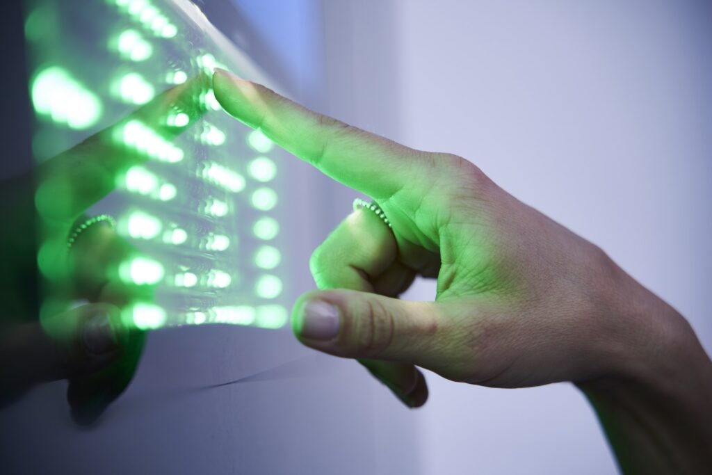 Detail of finger touching green led touchscreen